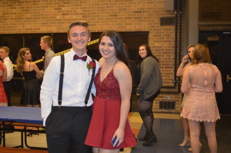 Emily Lenaghan (and Jack Billek) dressed in a burgundy low cut dress with a ruffled bodice.