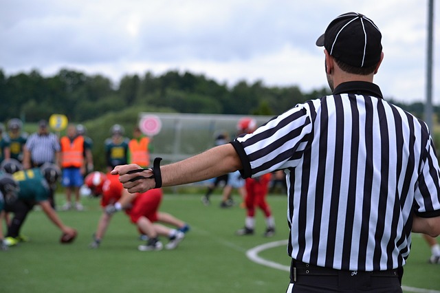 Referee officiates football game. 