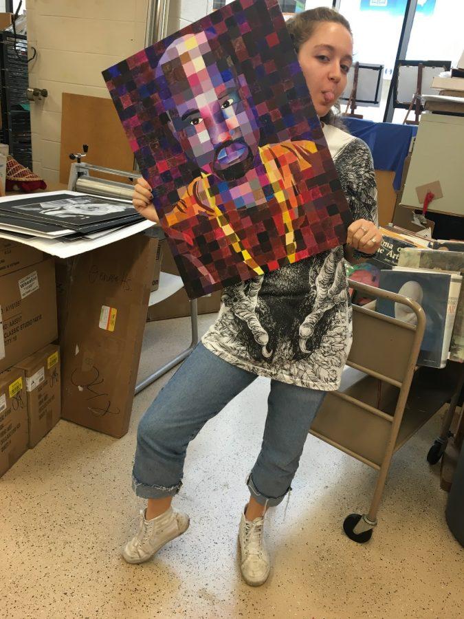 Senior Sammi Branshaw posing with her Kanye West painting